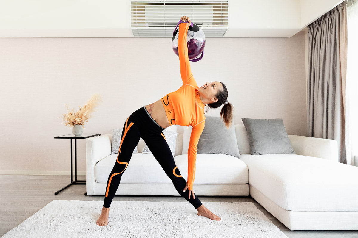 A woman working out in her living room with Fluid X’s aqua bags to illustrate best women home gym equipment in 2022 - Fluid X